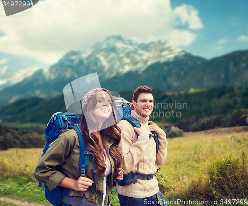 Image of smiling couple with backpacks hiking