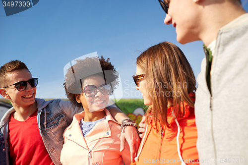 Image of happy teenage friends in shades talking on street