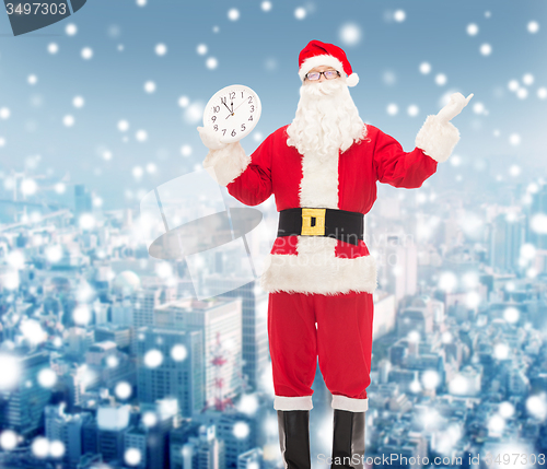 Image of man in costume of santa claus with clock