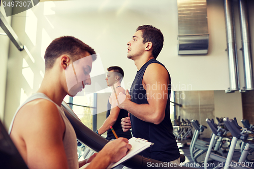 Image of men exercising on treadmill in gym