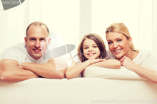 Image of smiling parents and little girl at home