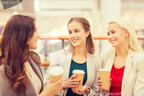 Image of young women with shopping bags and coffee in mall