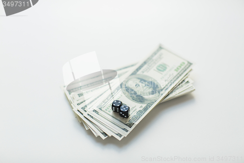 Image of close up of black dice and dollar cash money