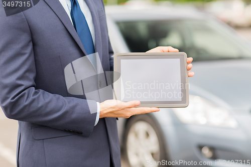Image of close up of young man with tablet pc and car