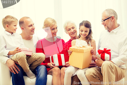 Image of smiling family with gifts at home