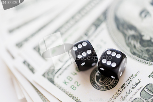 Image of close up of black dice and dollar cash money