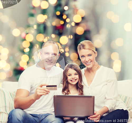 Image of happy family with laptop computer and credit card