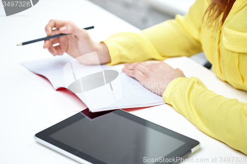 Image of close up of woman with tablet pc and notebook