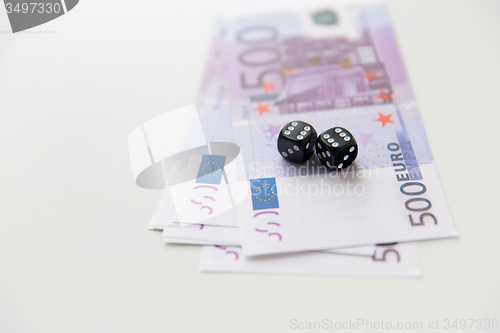 Image of close up of black dice and euro cash money