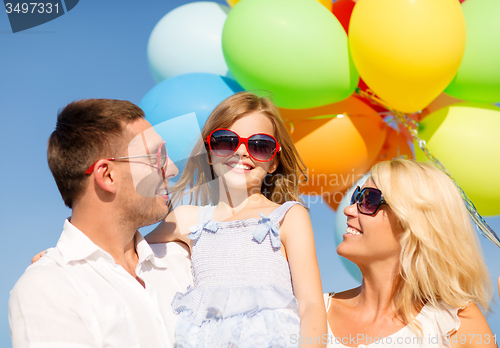Image of happy family with colorful balloons outdoors