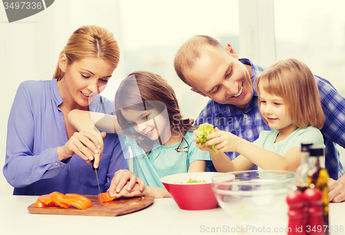 Image of happy family with two kids making dinner at home