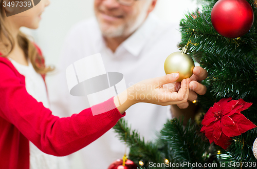 Image of close up of happy family decorating christmas tree