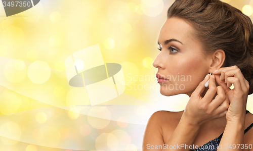 Image of smiling woman in evening dress wearing earrings