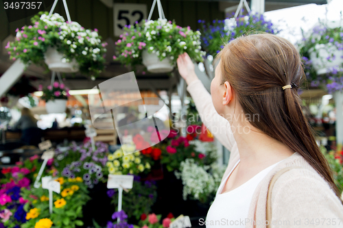 Image of woman choosing flowers at street market