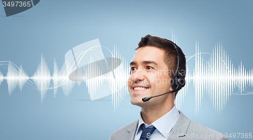 Image of businessman in headset over sound wave or diagram