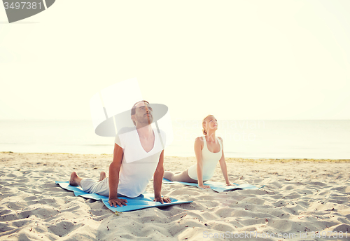 Image of couple making yoga exercises outdoors