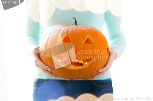 Image of close up of woman with pumpkins at home