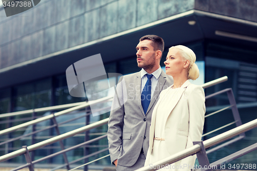 Image of serious businessmen standing over office building