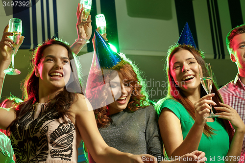 Image of smiling friends with glasses of champagne in club