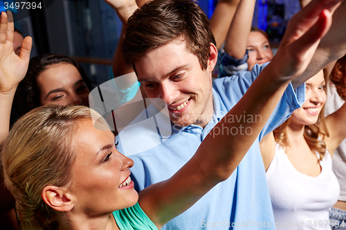 Image of smiling friends at concert in club