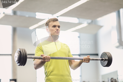 Image of man doing exercise with barbell in gym