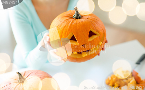 Image of close up of woman with pumpkins at home