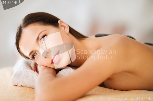 Image of beautiful woman in spa salon with hot stones