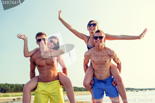 Image of smiling friends having fun on summer beach