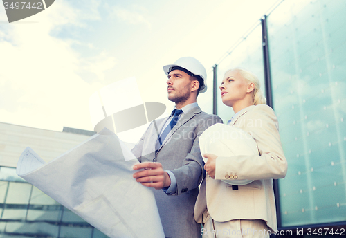 Image of businessmen with blueprint and helmets