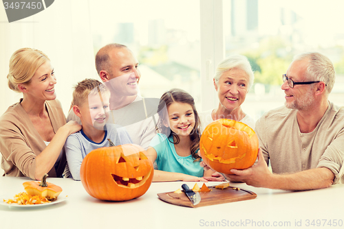 Image of happy family sitting with pumpkins at home