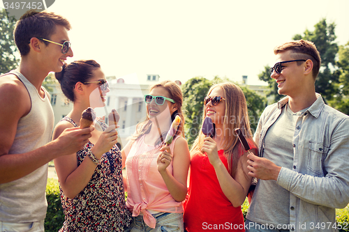 Image of group of smiling friends with ice cream outdoors