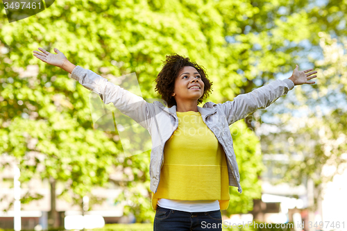 Image of happy african american young woman in summer park