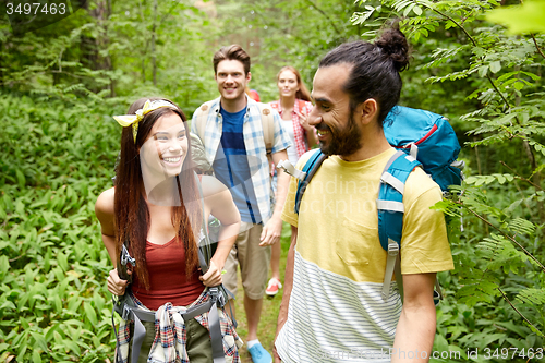 Image of group of smiling friends with backpacks hiking