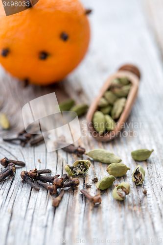 Image of Spices and orange with clove buds.