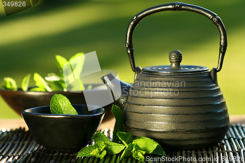 Image of Black asian teapot with mint tea