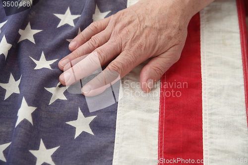 Image of man with hand on USA flag