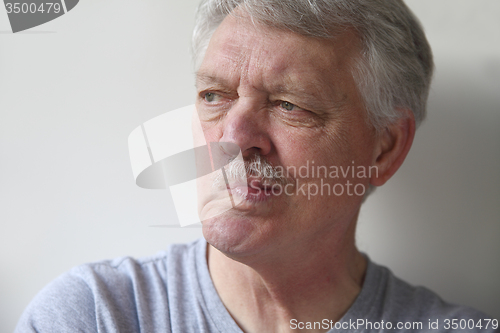 Image of senior man distorts his mouth