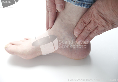 Image of man with hands on ankle	