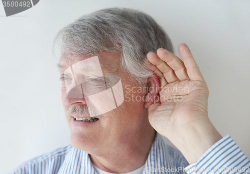 Image of Mature man has trouble hearing.	