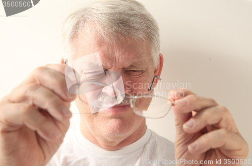 Image of senior man with dirty glasses 
