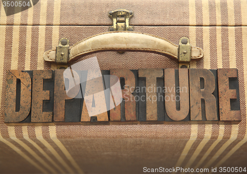 Image of departure word on old luggage