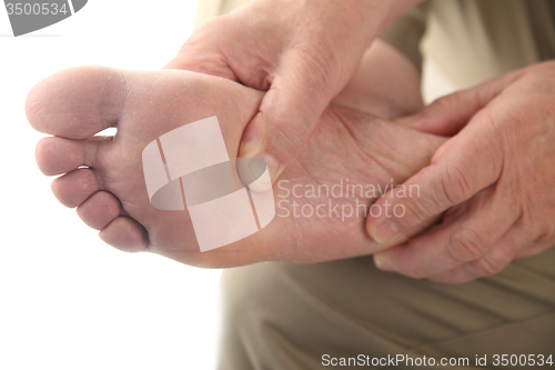 Image of a man checks his aching foot