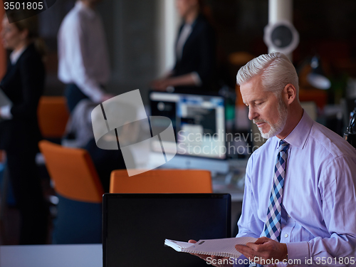 Image of senior business man with his team at office