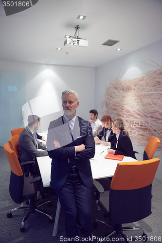 Image of senior business man with his team at office