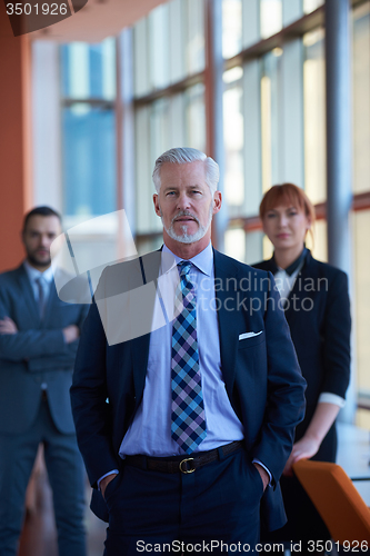 Image of senior business man with his team at office