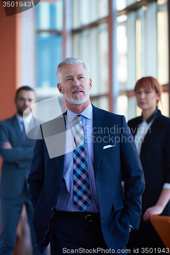 Image of senior business man with his team at office