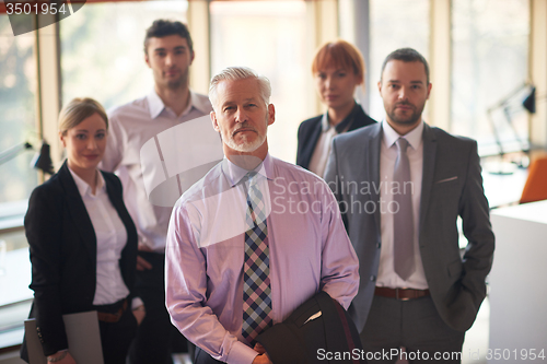 Image of senior business man with his team at office