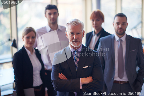 Image of senior business man with his team at office