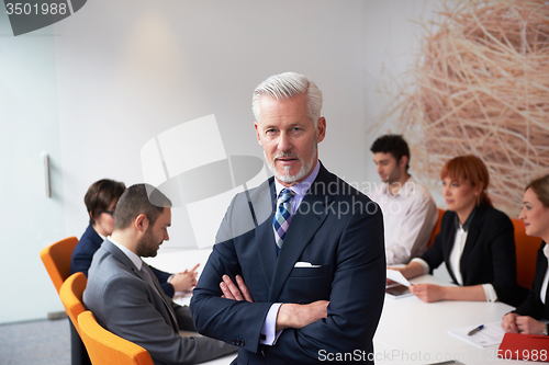 Image of senior business man with his team at office