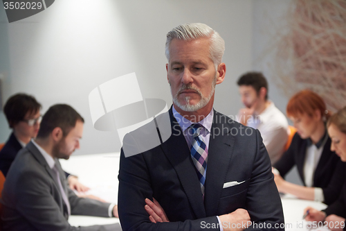 Image of senior business man with his team at office